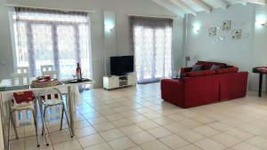 a living room with a red couch and a tv at Villa Persephone in Halikounas