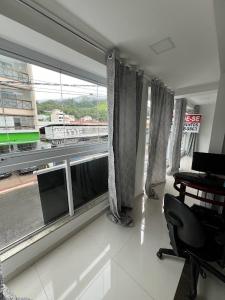 Zimmer mit einem Fenster und Blick auf einen Zug in der Unterkunft Lindo apartamento 1 quarto próximo a Rua de Lazer Domingos Martins in Domingos Martins