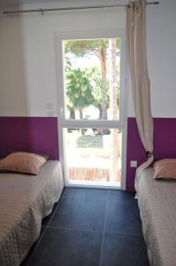 アルジェレス・シュル・メールにあるAppartement de 2 chambres avec piscine partagee terrasse et wifi a Argeles sur Mer a 3 km de la plageのベッドルーム1室(ベッド2台、大きな窓付)
