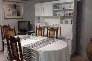 comedor con mesa, sillas y TV en One bedroom chalet with shared pool terrace and wifi at Sieso de Huesca, en Sieso de Huesca