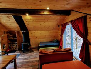 a log cabin with a bed and a fireplace at Aux Berges du lac Castor in Saint-Paulin