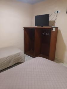a bedroom with a bed and a desk with a television at RESIDENCIAL SILVIA in Puerto Iguazú