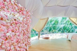 una habitación con una pared cubierta de flores rosas en Unique Escapes - Rosé All Day Geodome, en Monticello