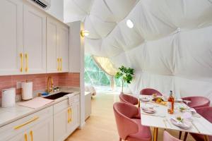 a kitchen with a table and pink chairs in a room at Unique Escapes - Rosé All Day Geodome in Monticello