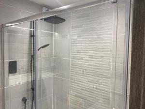 a shower with a glass door in a bathroom at Modern studio in natural surroundings in Four Oaks