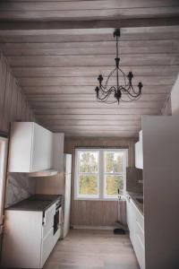 eine Küche mit einer Decke mit einem Kronleuchter und einem Fenster in der Unterkunft Bontveit Villa s in Bergen
