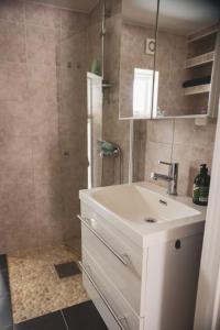 ein Badezimmer mit einem weißen Waschbecken und einer Dusche in der Unterkunft Bontveit Villa s in Bergen