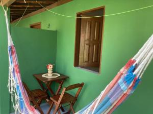 Habitación con mesa, sillas y pared verde. en Caju com Mel, en Moreré