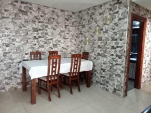 a dining room with a white table and chairs at Appartement Islane Agadir avec piscine in Agadir