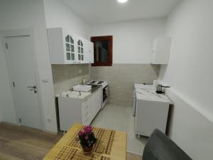 a kitchen with white appliances and a table in it at Zoka in Surčin