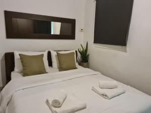 - une chambre avec un lit blanc et des serviettes dans l'établissement Apartment in the heart of the city 3A, à Larissa