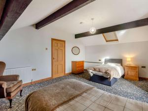 a bedroom with two beds and a couch and a chair at 3 Bed in Duddon Valley 89417 in Ulpha