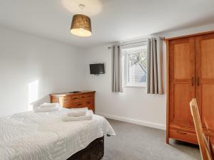 a bedroom with a bed and a dresser and a window at 2 bed in Crediton 66576 in Nymet Tracey