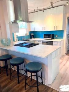 a kitchen with a counter with three stools around it at Casita California - Private house with backyard in San Diego