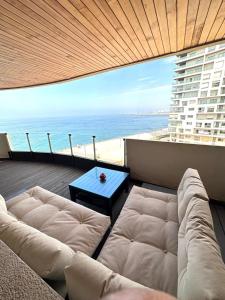 - un salon avec un canapé et une vue sur l'océan dans l'établissement Magnifique appartement pleine vue mer Marina Casablanca, à Casablanca