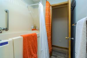 a bathroom with an orange shower curtain next to a tub at Pendleton House - Complimentary Wine Tasting in Walla Walla +16 photos