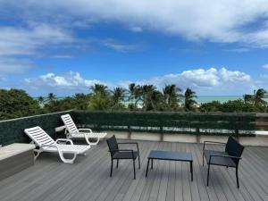 um deque com cadeiras e mesas e vista para o oceano em Apartments on Ocean Drive em Miami Beach