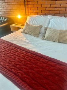 Una gran cama roja y blanca con almohadas. en Casa do Coité en Río de Janeiro