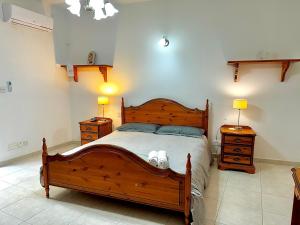 a bedroom with a wooden bed and two night stands at Holiday Home in St. Paul’s Bay in St Paul's Bay