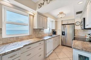 a kitchen with white cabinets and a large window at San Marco 5th Floor with Private Beach in Venice