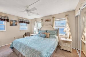 um quarto com uma cama com um edredão azul e janelas em San Marco 5th Floor with Private Beach em Venice mais 41 fotografias