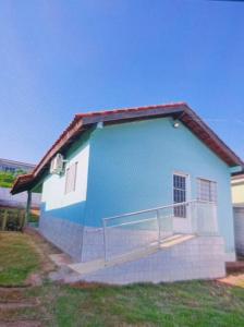 una casa azul y blanca con una escalera. en Casa Bosque da Saudade, en Barra do Garças