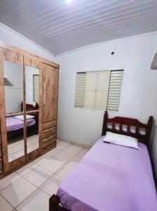 1 dormitorio con cama y espejo. en Casa Bosque da Saudade en Barra do Garças
