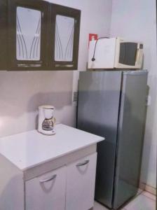 a kitchen with a refrigerator and a microwave at Casa Bosque da Saudade in Barra do Garças
