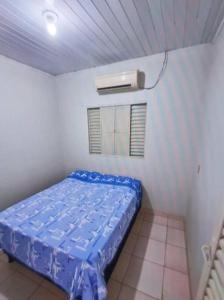 Un pequeño dormitorio con una cama azul en una habitación en Casa Bosque da Saudade en Barra do Garças