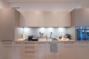 a kitchen with white cabinets and a sink at Loft DV1 - Bellissimo loft in Città Vecchia Locarno in Locarno