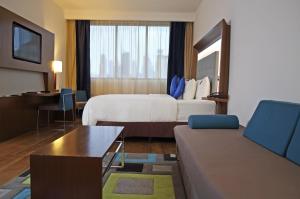 ein Hotelzimmer mit einem Bett und einer Couch in der Unterkunft Novotel Panama City in Panama-Stadt