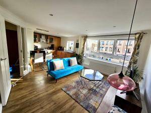 sala de estar con sofá azul y ventana en Home2 Home - Market Rise en Cambridge
