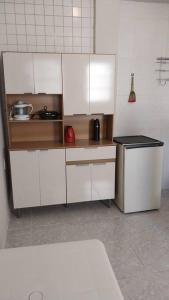 a kitchen with white cabinets and a counter top at kitnet Cidade 2000 in Fortaleza