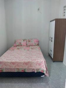 a bedroom with a bed and a dresser in it at kitnet Cidade 2000 in Fortaleza