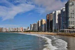 a view of a beach with tall buildings and the ocean at kitnet Cidade 2000 in Fortaleza