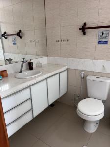 uma casa de banho com um WC branco e um lavatório. em POUSADA DA NANA em Jacaraípe