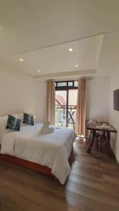- une chambre avec un grand lit et une table dans l'établissement Baguio Condotel with balcony Near Session & SM, à Baguio