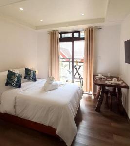 - une chambre avec un lit, une table et une fenêtre dans l'établissement Baguio Condotel with balcony Near Session & SM, à Baguio