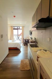 - une cuisine avec évier et un lit dans une chambre dans l'établissement Baguio Condotel with balcony Near Session & SM, à Baguio