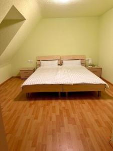1 dormitorio con 1 cama grande y suelo de madera en Gasthaus Hasen - Grill Masters en Geislingen