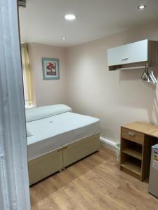 a small bedroom with a bed and a desk at Leman House in London