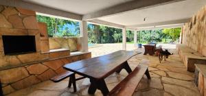 Habitación con mesa de madera y pared de piedra. en Fazenda Araras Eco Turismo - Acesso a cachoeira Araras en Pirenópolis