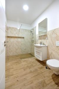 een badkamer met een douche, een wastafel en een toilet bij Čudesni drvored in Kikinda