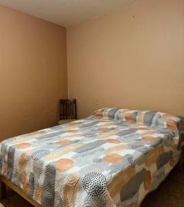 1 dormitorio con 1 cama con un edredón colorido en Departamento La Comarca 2, en Tepatitlán de Morelos