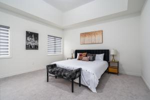 a white bedroom with a bed and a chair at Spacious 5-Bedroom Home with 4.5 Bathrooms: 3 Sassafras Road in Midhurst