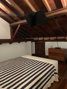 a bedroom with a bed with a black and white striped blanket at Casa centro histórico Paraty in Paraty