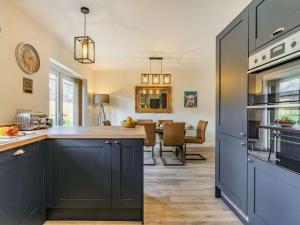 a kitchen with blue cabinets and a dining room at 3 Bed in Hackthorpe 86724 in Hackthorpe