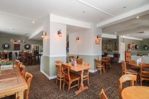 a dining room with wooden tables and chairs at Wren's Nest Manorcombe in Callington