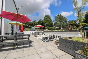 a park with benches and a chess board and umbrellas at Wren's Nest Manorcombe in Callington