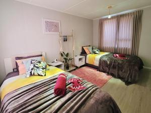 a room with two beds with towels on them at Gulf Red Vacation Home 2 Bedroom 2 Bathroom in Whangaparaoa